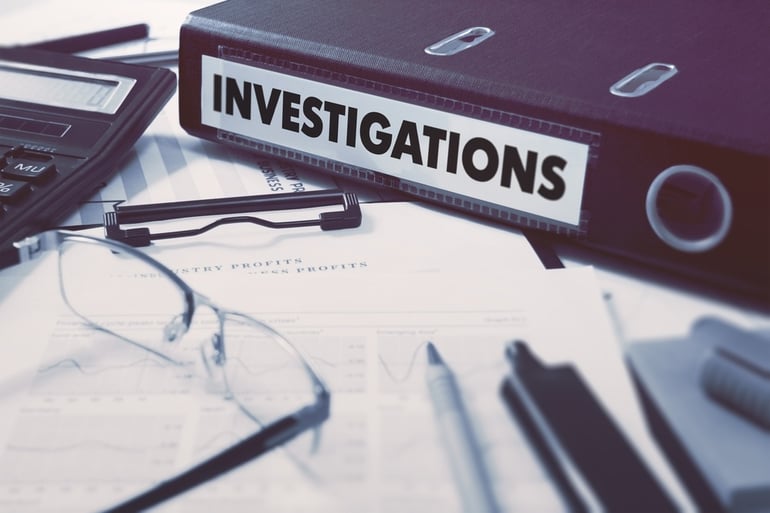 Ring Binder with inscription Investigations on Background of Working Table with Office Supplies, Glasses, Reports. Toned Illustration. Business Concept on Blurred Background..jpeg